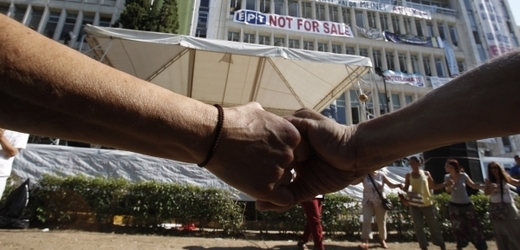 Lidé protestují před sídlem státní televize v Aténách. 